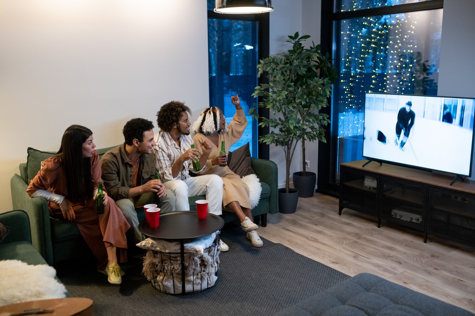 Friends enjoying a home theater speaker setup while watching sports.