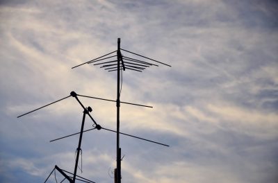 Residential antenna installation against a beautiful sky backdrop.